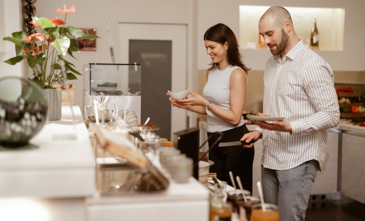 G&auml;ste w&auml;hlen frische Speisen vom abwechslungsreichen Fr&uuml;hst&uuml;cksbuffet im Hotel Rathaus Wien